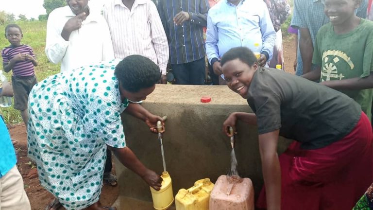 Villagers draw water from the newly-completed wells in Poyemi